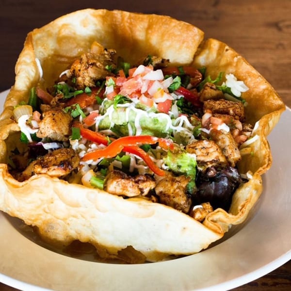 Favela's Mexican Grill taco salad in a crispy tortilla bowl with chicken, guacamole, and pico de gallo.
